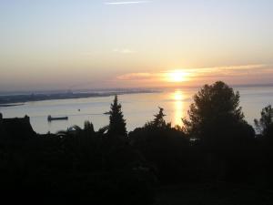 un coucher de soleil sur l'eau avec un bateau à l'intérieur dans l'établissement Quinta de Sao Filipe, à Setúbal