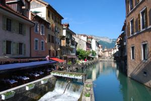 a canal in the middle of a city with buildings at Hôtel des Alpes in Annecy