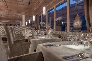 a restaurant with white tables and chairs with wine glasses at Alpen-Wellness Resort Hochfirst in Obergurgl