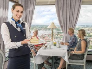 een serveerster met een taart in een restaurant bij Maritim Strandhotel Travemünde in Travemünde