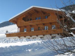 un gran edificio de madera en la nieve en Apartment Galtenberg, en Alpbach