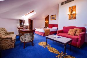 a hotel room with a bed and a couch and a table at Hotel El Bedel in Alcalá de Henares