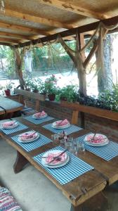 una mesa de picnic de madera con platos de comida. en Farm stay Lackovic, en Bilje