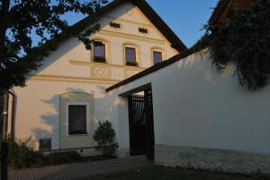 una casa blanca con una puerta negra y un edificio en Dvůr U kapličky, en Žďár nad Sázavou