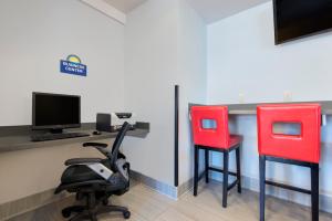 2 chaises rouges assises à côté d'un bureau avec un ordinateur dans l'établissement Hotel 1550 - SFO Airport West, à San Bruno