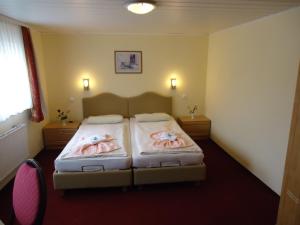 A bed or beds in a room at Hotel & Restaurant Beckmanns Winzerhaus