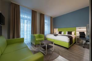 Pokój hotelowy z łóżkiem i biurkiem w obiekcie ibis Styles Offenburg City w mieście Offenburg