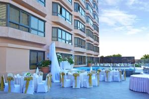 eine Reihe von Tischen und Stühlen mit weißen Tischen und Blumen in der Unterkunft Pyramisa Suites Hotel Cairo in Kairo