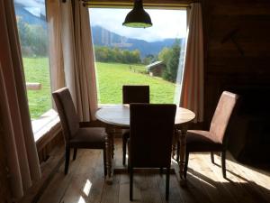 een tafel en stoelen in een kamer met een groot raam bij La Cubelette in Chamonix-Mont-Blanc