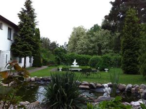 um jardim com uma fonte no meio de um lago em Natur& Waldhotel Johannesruh em Wesenberg