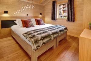 1 dormitorio con 1 cama en una habitación de madera en Chalet-Hôtel Inarpa, en La Clusaz