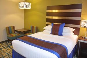 a hotel room with a bed and a table and chairs at Gateway Inn and Suites in Salida