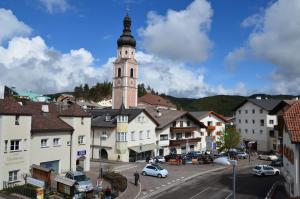 eine Stadt mit einem Uhrturm in der Ferne in der Unterkunft Gasthof Toni in Kastelruth