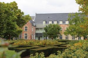 - un grand bâtiment en briques avec un jardin en face dans l'établissement Irish College Leuven, à Louvain