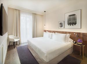 ein Hotelzimmer mit einem großen Bett und einem TV in der Unterkunft H10 Casa Mimosa 4* Sup in Barcelona