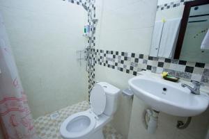 a bathroom with a toilet and a sink at Asta House in Kuta