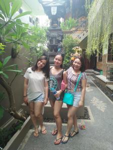 three girls posing for a picture in front of a building at Asta House in Kuta