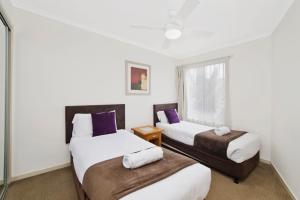 twee bedden in een kamer met een raam bij Beach Resort Apartment in Port Macquarie