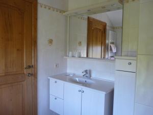 a white bathroom with a sink and a mirror at L'orchidée in Rochehaut