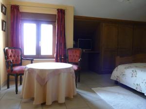 a room with a table and two chairs and a bed at L'orchidée in Rochehaut