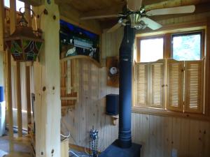 sala de estar con ventilador de techo y fogones en Chalet Saint-Thomas, en L'Anse-Saint-Jean