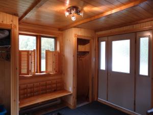 Habitación con paneles de madera y ventanas en una cabaña. en Chalet Saint-Thomas, en L'Anse-Saint-Jean