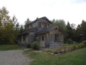 una casa vieja sentada en medio de un patio en Chalet Saint-Thomas, en L'Anse-Saint-Jean