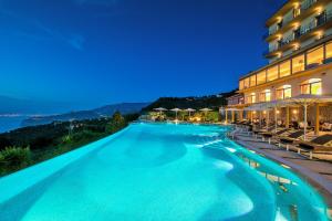 una piscina frente a un hotel por la noche en Grand Hotel Due Golfi, en SantʼAgata sui Due Golfi