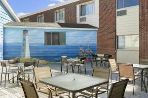 a patio with tables and chairs and a mural of a lighthouse at Days Inn by Wyndham Bridgewater Conference Center in Bridgewater