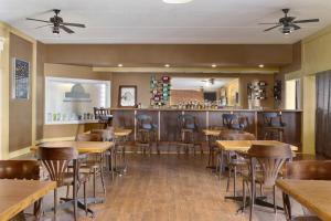 a restaurant with wooden tables and a bar at Days Inn by Wyndham Bridgewater Conference Center in Bridgewater