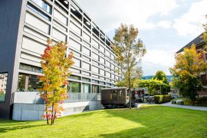 un edificio de oficinas con césped delante en HOTEL APART - Welcoming l Urban Feel l Design, en Risch-Rotkreuz