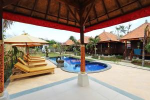 - Piscina resort con 2 sillas y sombrilla en Dream Beach Cottages, en Nusa Lembongan