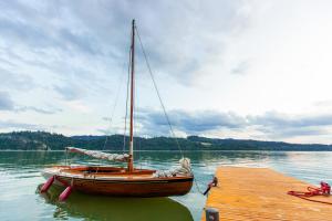 a boat sitting on the water next to a dock at Willa Jordanówka in Czorsztyn