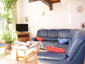 Rural lodging located in the small village في Radelange: غرفة معيشة مع أريكة زرقاء وطاولة