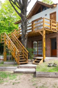 ein Haus mit einer Treppe, die zu einem Baum führt in der Unterkunft Cabañas Gonzalez in Villa Gesell