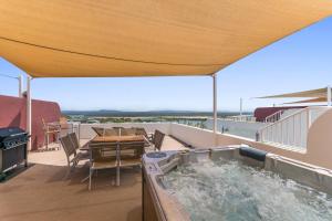 a hot tub on the balcony of a house at Bali Hai Apartments Noosa in Noosa Heads