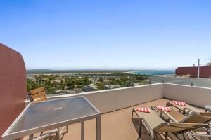 a balcony with chairs and a view of the ocean at Bali Hai Apartments Noosa in Noosa Heads