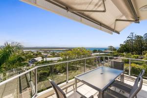 a balcony with a table and chairs and the ocean at Bali Hai Apartments Noosa in Noosa Heads