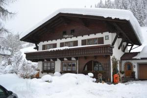 une maison recouverte de neige avec un tas de neige dans l'établissement Haus Thurner, à Wagrain