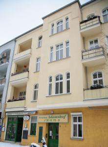 um grande edifício amarelo com janelas e varandas em Hotel-Pension Adamshof em Berlim