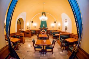 a dining room with tables and chairs and a mirror at Garni Hotel Leopold I in Novi Sad