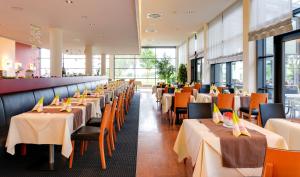 uma fila de mesas e cadeiras num restaurante em Novina Hotel Herzogenaurach Herzo-Base em Herzogenaurach