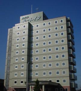 Un bâtiment avec un panneau en haut dans l'établissement Hotel Route-Inn Hon Hachinohe Ekimae, à Hachinohe