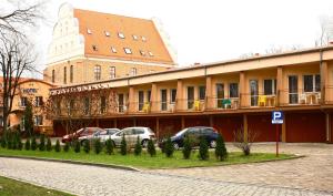 un edificio con auto parcheggiate di fronte di Hotel Zamek a Giżycko