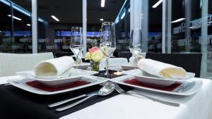 uma mesa com placas brancas e talheres sobre uma mesa em Dream Hotel em Velika Gorica