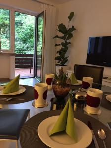 un comedor con una mesa con servilletas verdes. en Apartment - zentrumsnah, eigener Parkplatz und großer Balkon ins Grüne, en Baden-Baden