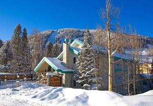 un pavillon de ski avec un panneau dans la neige dans l'établissement Alpine Village Suites, à Taos Ski Valley