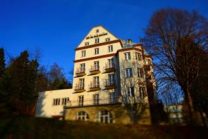 un alto edificio bianco con balcone di Rezydencja Zamek a Krynica-Zdrój