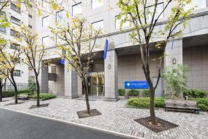 un grupo de árboles frente a un edificio en HOTEL MYSTAYS PREMIER Omori, en Tokio