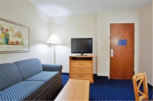 ein Wohnzimmer mit einem Sofa und einem Flachbild-TV in der Unterkunft Holiday Inn Express Ashland, an IHG Hotel in Ashland